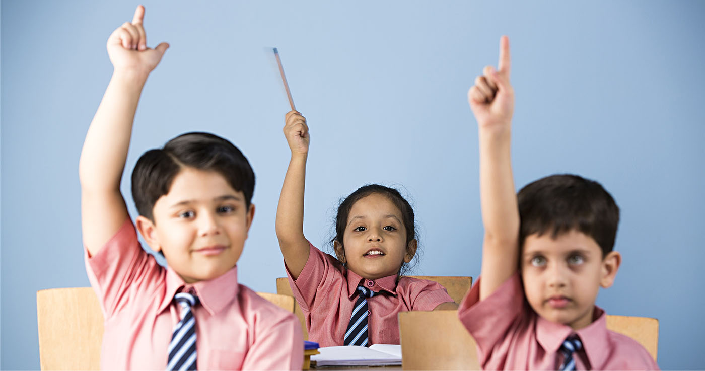 KIds raising hands in classroom